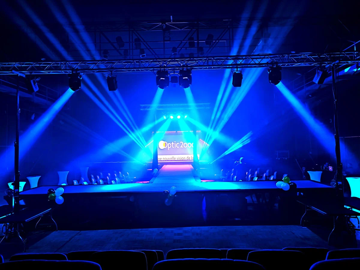 Podium de défilé éclairé en bleu, structure et lyres
